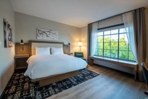 a bedroom with a large bed and a large window at Hotel Rose in Rockford