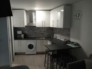 a kitchen with white cabinets and a washing machine at LIA in Muxia