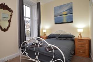 a bedroom with a bed and a window at Secret Coast Getaway in Tighnabruaich