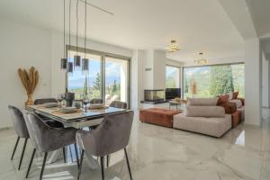 a living room with a dining table and a couch at Villa Sadova Private pool Panoramic view in Kalamata