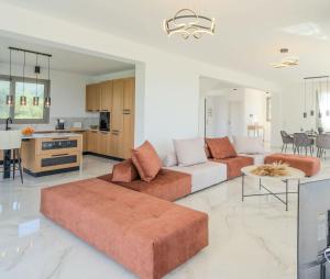 a living room with two couches and a kitchen at Villa Sadova Private pool Panoramic view in Kalamata