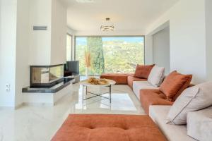 a living room with a couch and a tv at Villa Sadova Private pool Panoramic view in Kalamata +42 photos