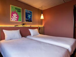 two beds sitting next to each other in a room at greet Hotel Reims Tinqueux in Reims