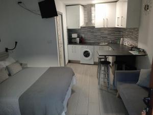 a bedroom with a bed and a kitchen with a table at LIA in Muxia