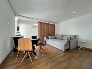 a living room with a bed and a table and chairs at Ziza Hospedagem in Maringá +65 photos