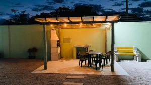 a patio with a table and chairs under a tent at Pousada Jabuticabeira in Jaguaruna