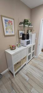 a white cabinet with a microwave on top of it at Lawson Lodge in Alveston