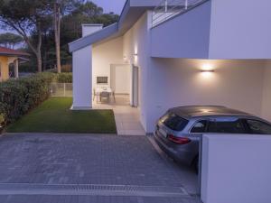 a car parked in front of a white house at Villa Lisa in Bibione