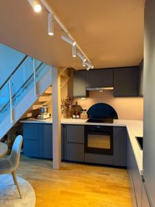 a kitchen with blue cabinets and a staircase at Leilighet i Kristiansand in Kristiansand +10 photos