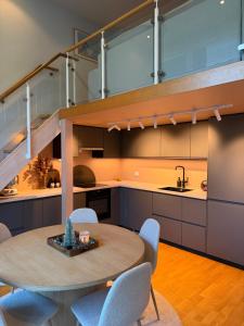 a kitchen with a round table and blue chairs at Leilighet i Kristiansand in Kristiansand