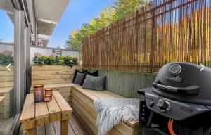 a barbecue on a patio with a bench and a table at Leilighet i Kristiansand in Kristiansand