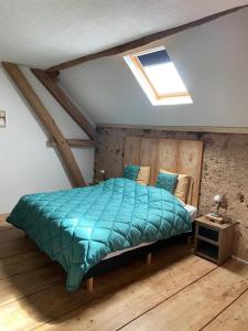 a bedroom with a bed with a green comforter at B&B Les Fruits du Passau in Saint-Désiré