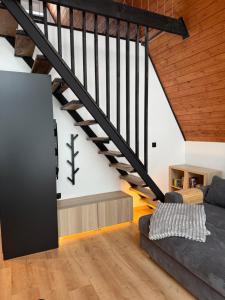 a living room with a couch and a staircase at Chalet Tri pramene in Moravské Lieskové