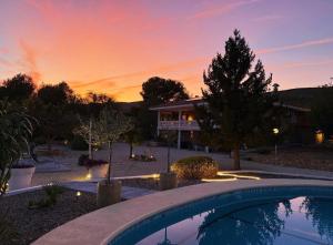 a house with a swimming pool in front of a sunset at Atidos vakantie appartementen in Ontinyent