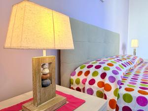 a lamp sitting on a table next to a bed at Casa Zoe in Gallipoli