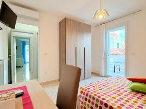a bedroom with a bed and a table and a window at Casa Zoe in Gallipoli
