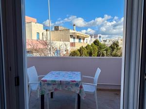 a table and chairs on a balcony with a view of a city at Casa Zoe in Gallipoli