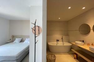 a bedroom with a bed and a tub and a sink at Villa Concarella Di Conca in Conca