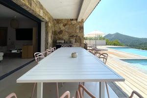 a dining room with a table and a swimming pool at Villa Concarella Di Conca in Conca