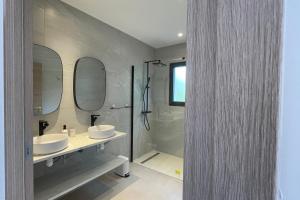 a bathroom with two sinks and a shower with mirrors at Villa Concarella Di Conca in Conca