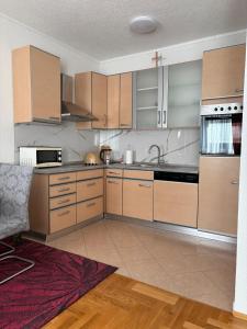 a kitchen with wooden cabinets and stainless steel appliances at APARTMAN Iva in Tomislavgrad