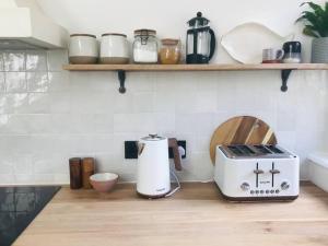 a kitchen counter with a coffee maker and a toaster at Manderley Cottage, Mousehole in Mousehole