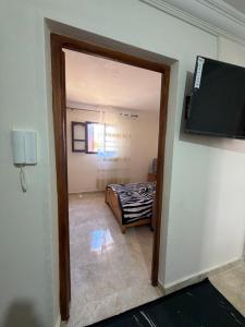 a doorway to a room with a bed and a television at Samadis Home 2 in Larache