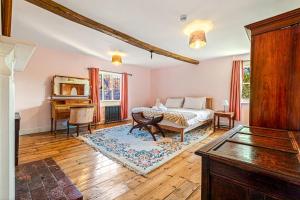 a bedroom with a bed and a table and a piano at Huckleberry Farm House in Basildon