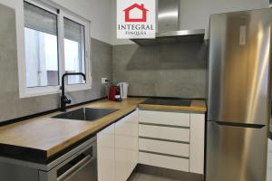 a kitchen with a sink and a stainless steel refrigerator at Apartament Marea Alta in San Juan de Palamós