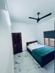ein Schlafzimmer mit zwei Betten und einem Deckenventilator in der Unterkunft Stay loop in Cherambādi