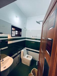 ein Badezimmer mit Toilette und Waschbecken in der Unterkunft Stay loop in Cherambādi