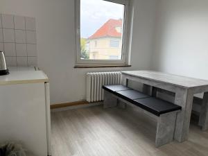 a table with a bench in a kitchen with a window at 3-Zimmer Ferienunterkunft in Bad Salzuflen +3 photos