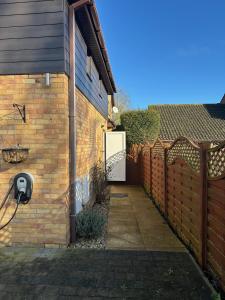 a brick fence with a white door on a house at The Wold - Air-Conditionned Studio Burton Latimer in Burton Latimer