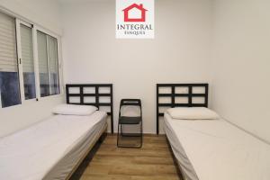 a room with two beds and a chair in it at Apartament Marea Alta in San Juan de Palamós