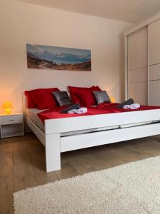 a white bed with red pillows in a room at Villa Julija with Private Pool in Bilišane +25 photos
