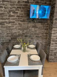 a white table with chairs and a tv on a brick wall at Villa Julija with Private Pool in Bilišane