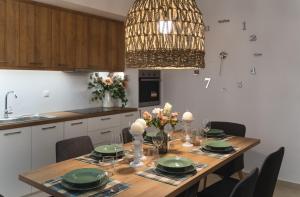 a kitchen with a wooden table with chairs and a chandelier at Anemone House in Mesokhórion