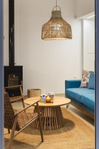 a living room with a table and a blue couch at Anemone House in Mesokhórion