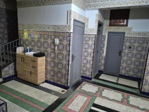 a bathroom with tiles on the walls and two doors at Apparemment familiale villa 110 m2 jardin et piscine in MeknèsKatine +18 photos