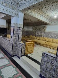 a living room with a couch and a table at Apparemment familiale villa 110 m2 jardin et piscine in MeknèsKatine