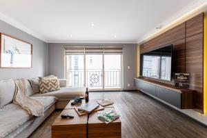 a living room with a couch and a tv at Capitalia Obelisk Polanco in Mexico City