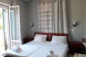 a bedroom with two beds and a window at Ellis Studios in Meganisi