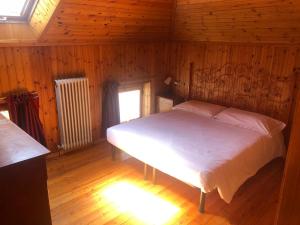 a bedroom with a bed in a wooden room at La Mansarda di Tiziano in Pieve di Cadore