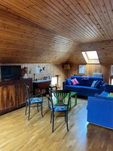 a living room with a blue couch and chairs at La Mansarda di Tiziano in Pieve di Cadore