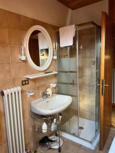 a bathroom with a sink and a shower at La Mansarda di Tiziano in Pieve di Cadore +13 photos