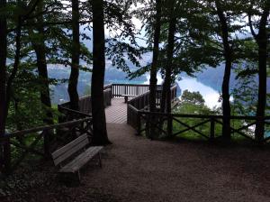 a bench on a deck with a view of a lake at La Mansarda di Tiziano in Pieve di Cadore