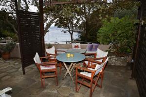 a patio with a table and chairs with a view of the ocean at Ghermaniko Guesthouse in Damouchari