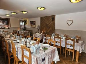 a restaurant with tables and chairs with white tablecloths at Willa Litworówka in Biały Dunajec +25 photos