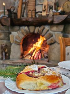 a pastry sitting on a plate in front of a fireplace at Willa Litworówka in Biały Dunajec