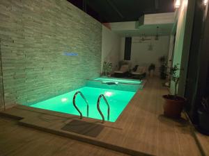 a swimming pool in a room with a brick wall at Sea Wind Chalet in Qalhāt